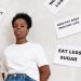 African American woman stands near motivational health slogans on the wall, promoting a positive lifestyle.